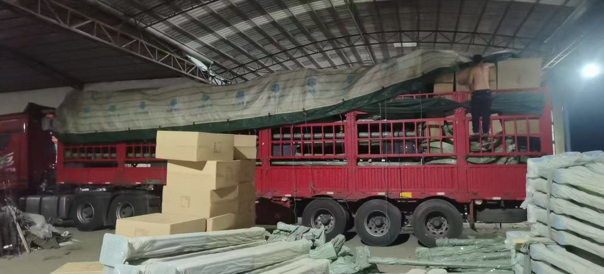 Cartons of integrated solar street lights and wrapped poles loaded into a freight truck for a full-container shipment
